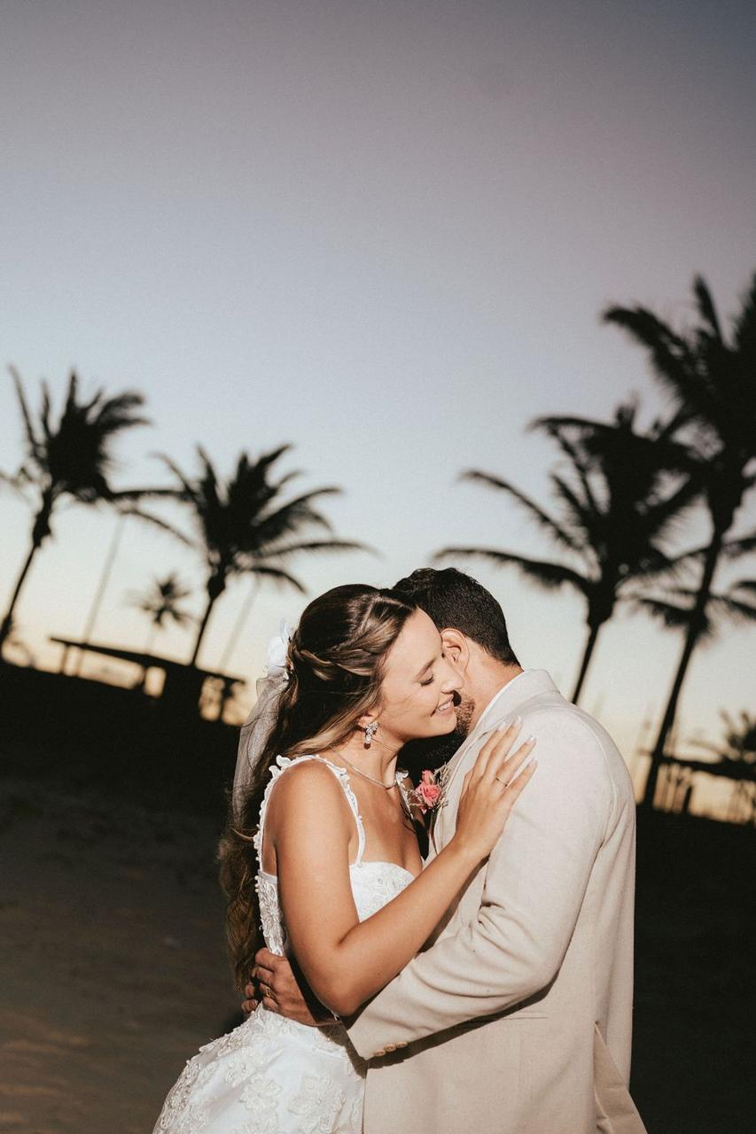 Casal de noivos abraçados na praia