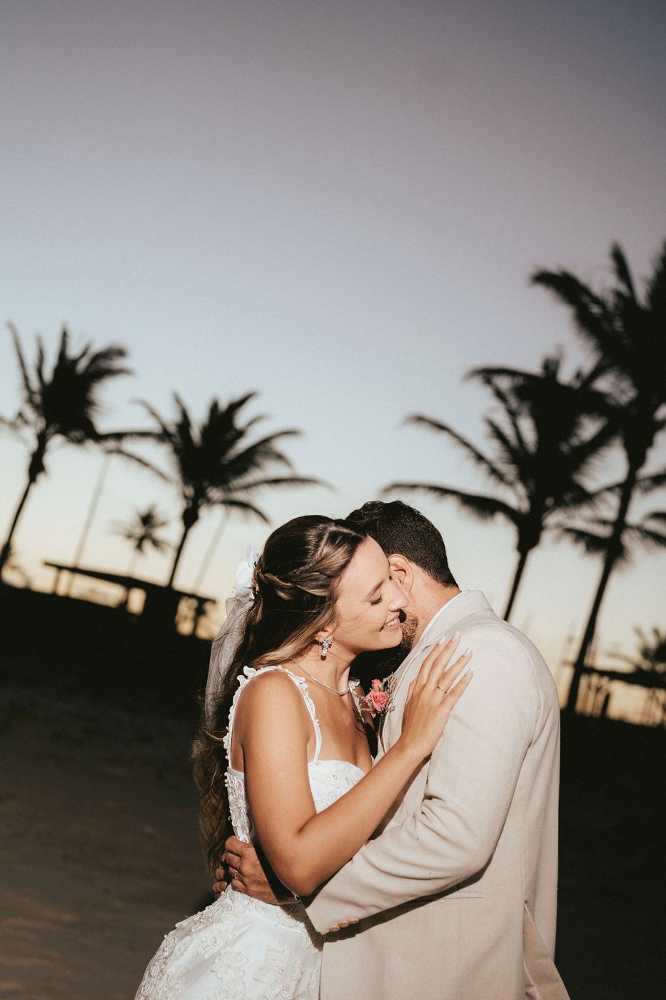 Casal de noivos abraçados na praia