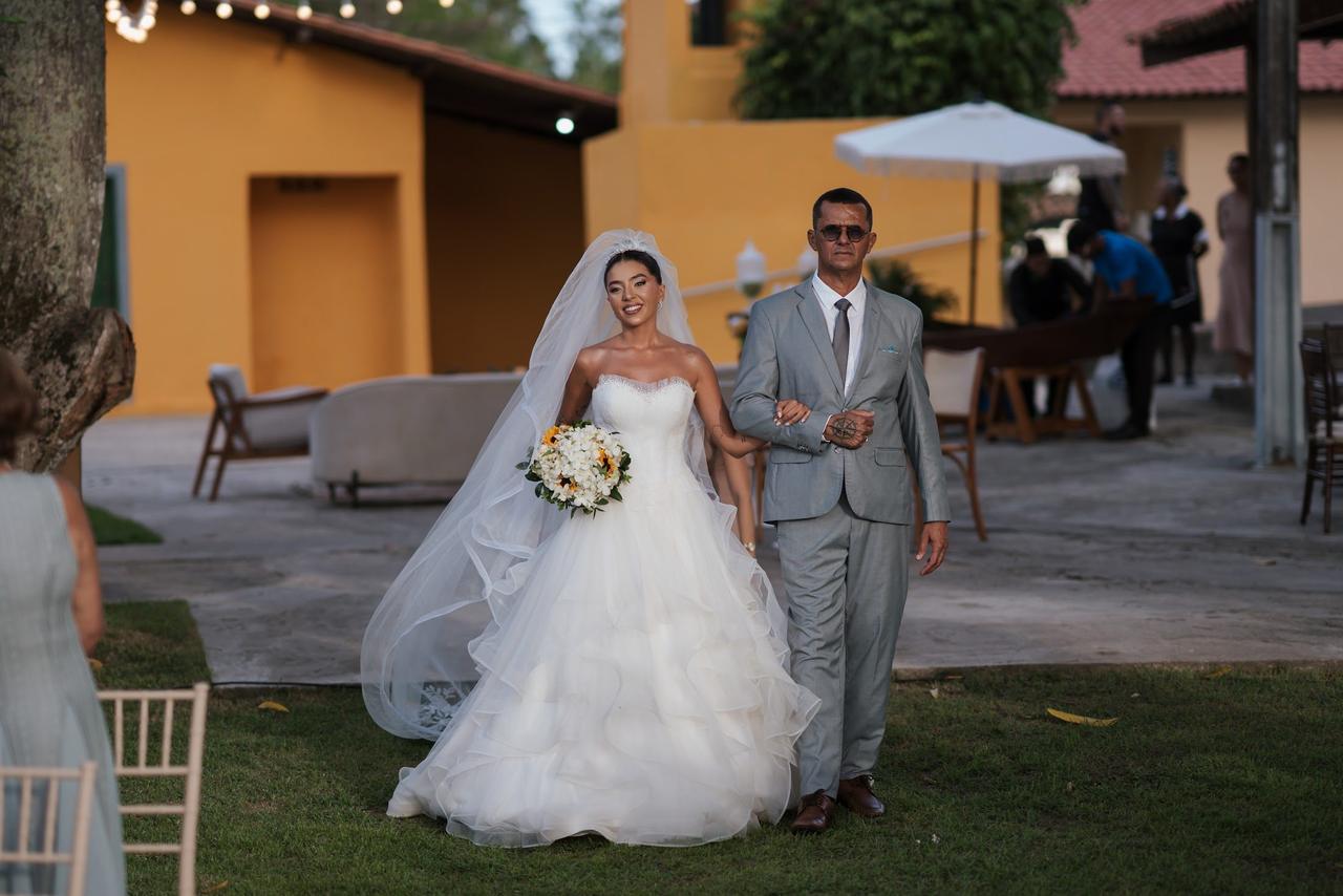 Noiva caminhando com o pai até o altar