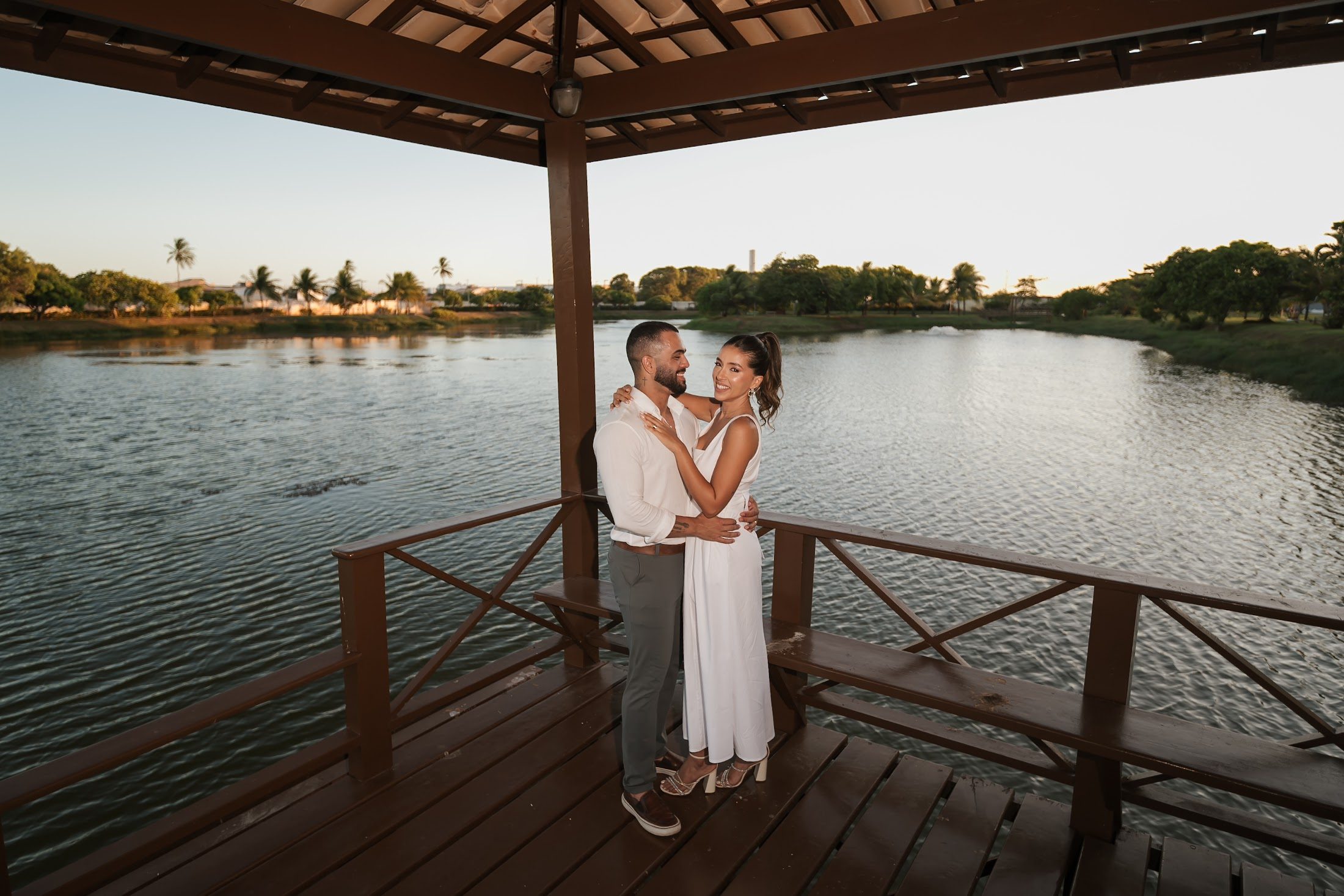 Gabi e Caio no deque de um lago durante o ensaio