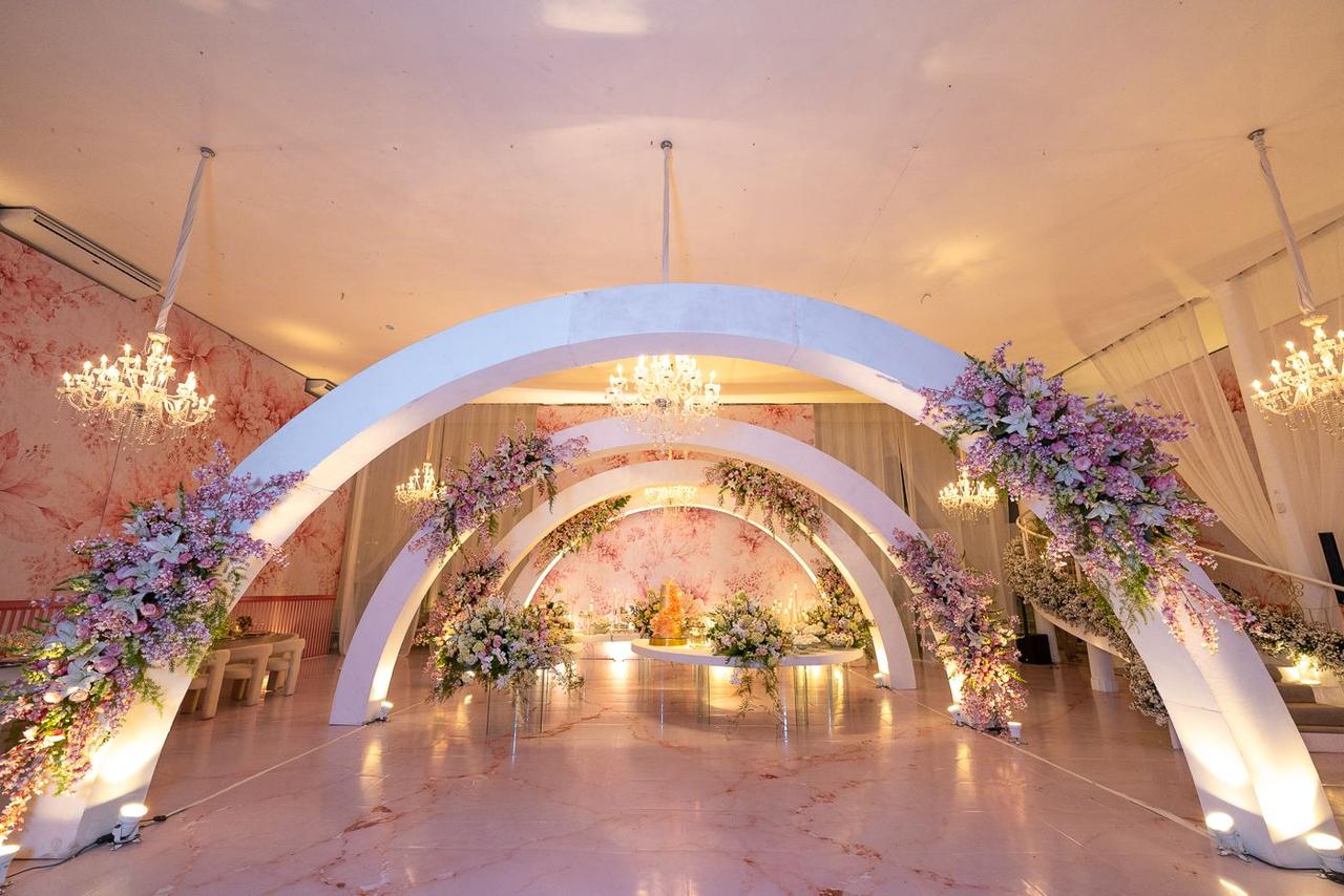 Decoração de aniversário com arcos brancos e flores