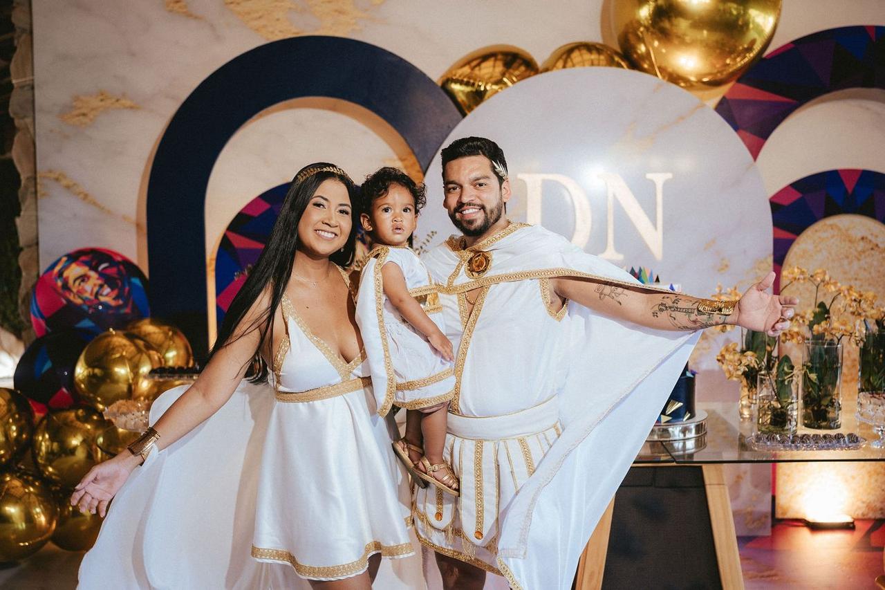 Família com a decoração da festa ao fundo
