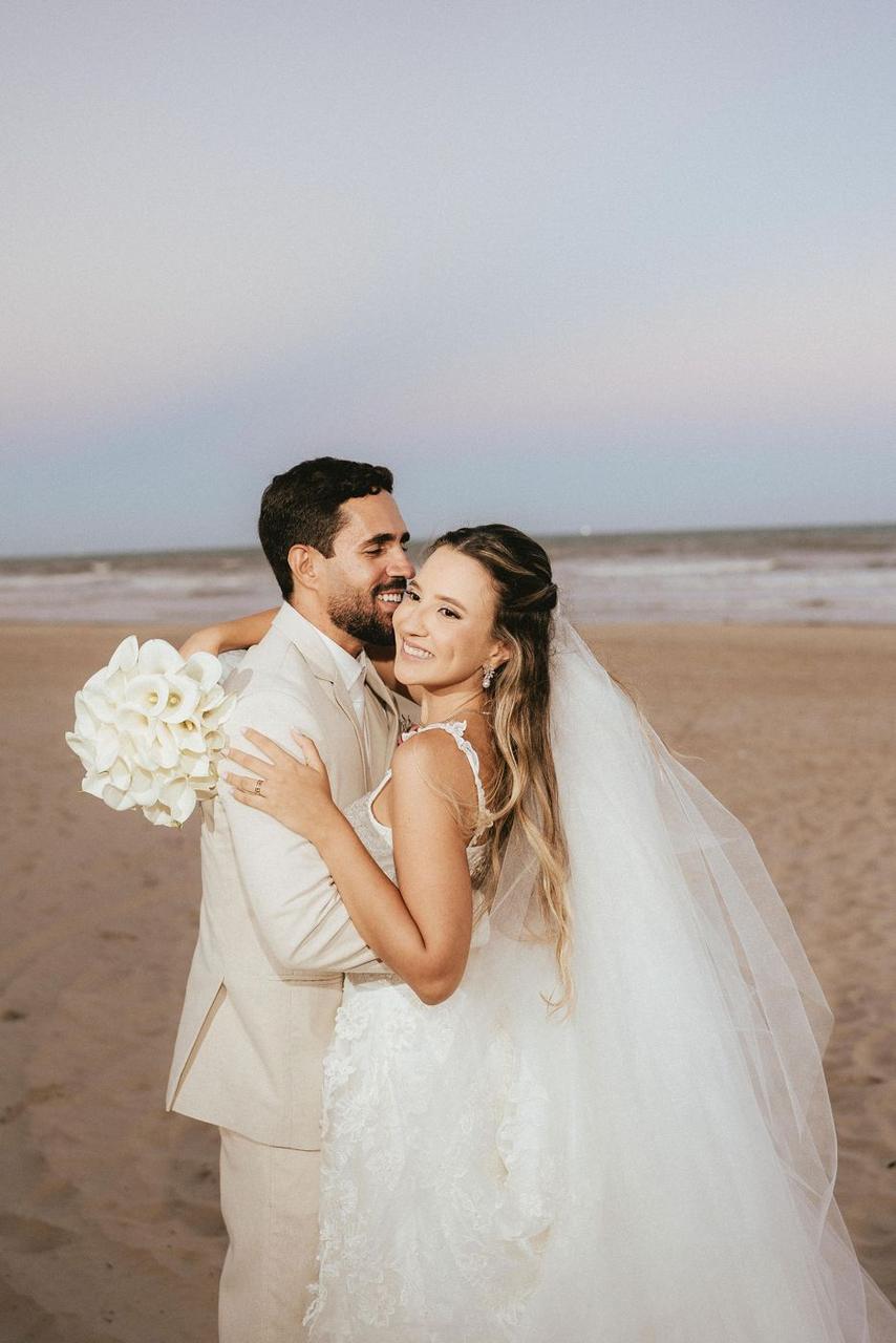 Casal de noivos na praia ao pôr do sol