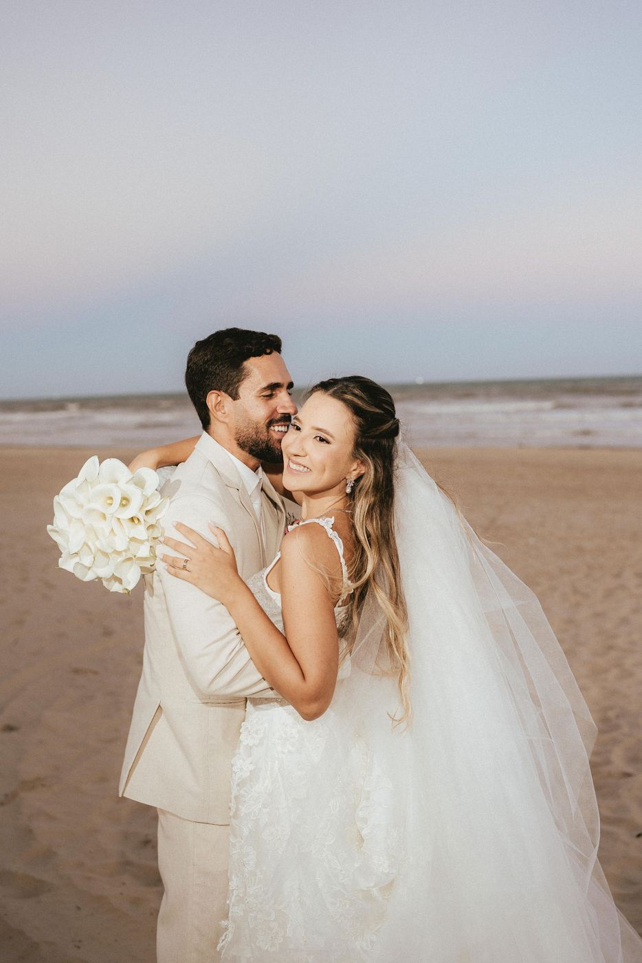 Casal de noivos na praia ao pôr do sol